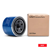 A blue and silver automotive oil filter shown next to its original brown cardboard packaging box, which is branded 'KMA Genuine Parts'. A small red 'NDE' logo sticker is visible in the bottom right corner.