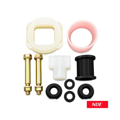 A set of industrial mechanical parts and hardware arranged on a white background, including two brass pins with hex nuts, black rubber O-rings, a white plastic T-piece, a pink sleeve, a cream-colored square ring, and a black cylindrical bushing. An 'NDE' logo sticker is visible in the bottom right corner.