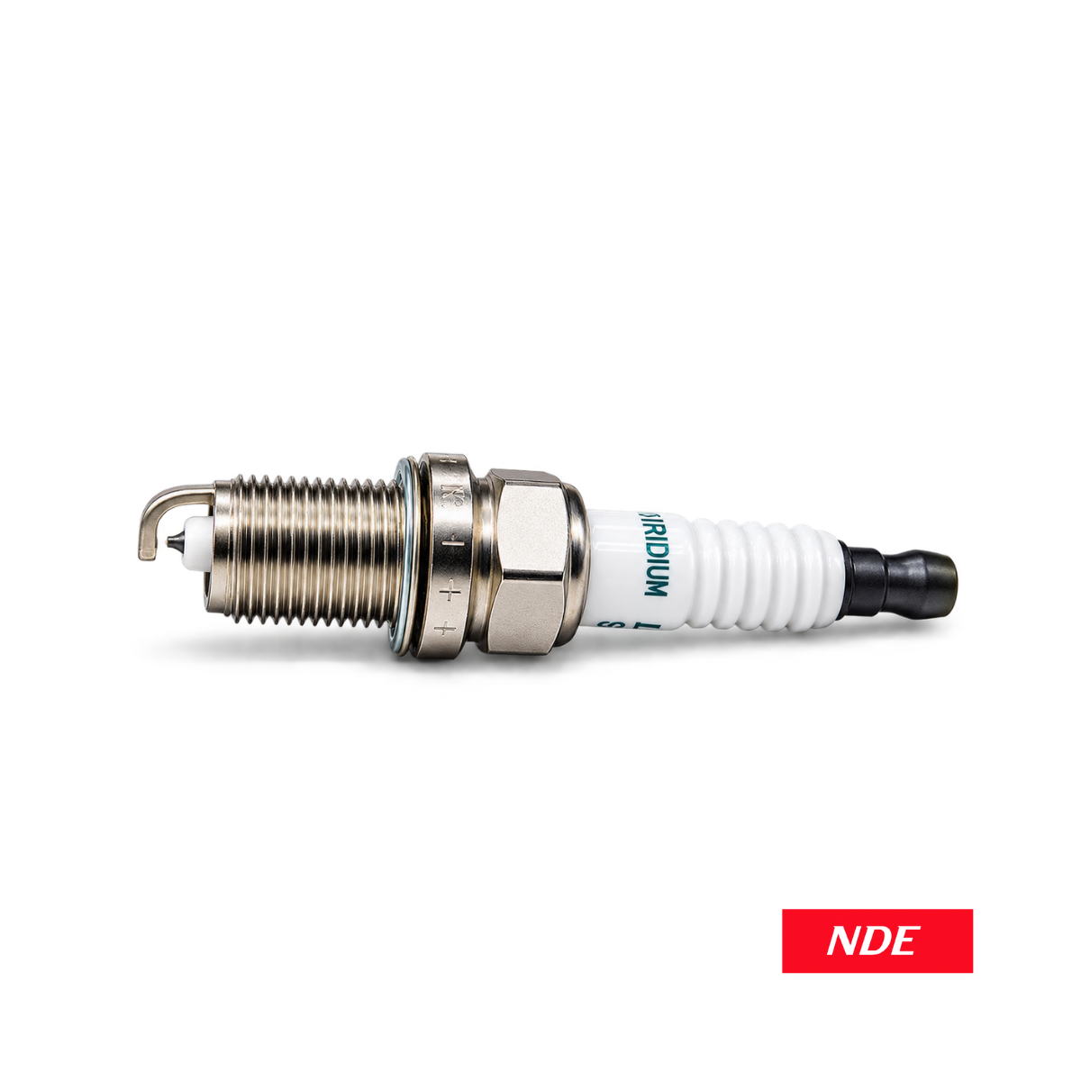 A single spark plug shown horizontally on a clean white background, with a red label in the bottom-right corner reading NDE. The spark plug has a silver metal body, a white ceramic insulator, and blue printed text.